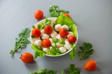 Mozzarella, kiraz domatesleri ve yeşilliklerle nefis bir kompozisyon..