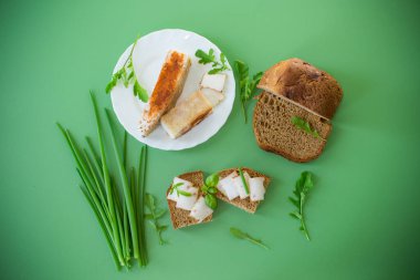 Çavdar ekmeğine domuz yağlı sandviç ve üstüne yeşil soğan..