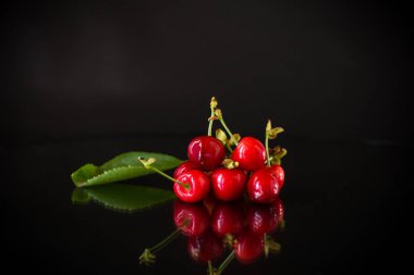 Siyah arka planda lezzetli kırmızı kirazlar.