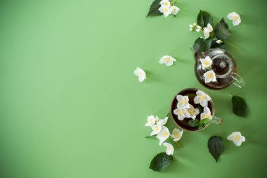 Yukarıdan cam çaydanlıkta yaseminli yeşil çay.