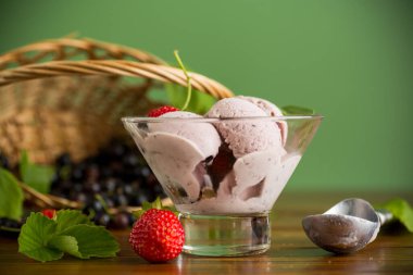 Yeşil arka planda yalıtılmış çilekli ve kuşüzümlü soğuk yaz tatlısı..