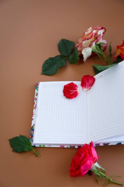 Güllerle dolu romantik bir sabah, bir defter ve bir fincan kapuçino..