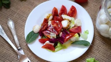 Mozzarella, domates ve yeşil yapraklı aperatif..