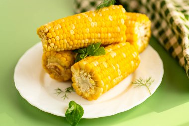 Yeşil arka planda yakın plan altın mısır taneleri.