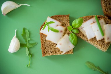 Çavdar ekmeğine domuz yağlı sandviç ve üstüne yeşil soğan..