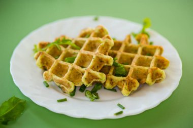 Yeşil bir yüzeye servis edilen vejetaryen kabaklı waffle..