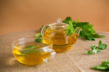 Kahverengi arka planda naneli ve frenk üzümlü bitki çayı..