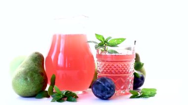 Beyaz bir zemin üzerinde erik ve armut ile taze meyve içeceği.