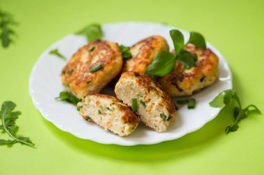 Yeşil arka planda izole edilmiş bir tabakta ev yapımı tavuk kıymalı pirzola..