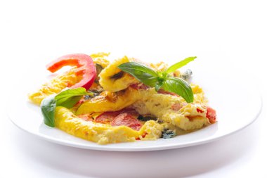 Beyaz arka planda sebzeli ve otlu omlet..