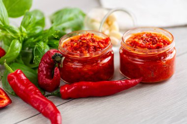 Acı biberli taze baharat sosu ve masada bitkiler..