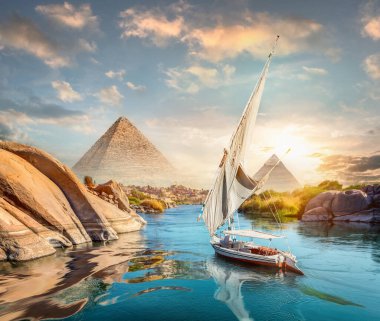 Aswan 'da gün batımında Nil Nehri ve tekneler ve piramitler