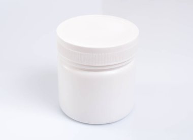 Beyaz arkaplanda beyaz yuvarlak plastik kavanoz