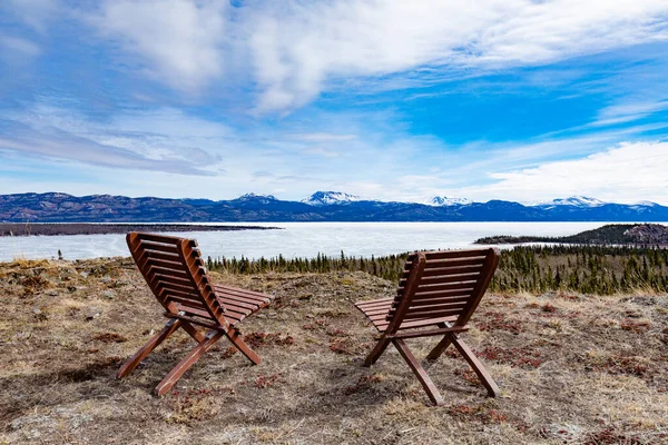 位于加拿大Yt育空地区的两把椅子 俯瞰着仍被冰覆盖的拉贝尔热湖 Lake Laberge 春天针叶林森林景观 — 图库照片
