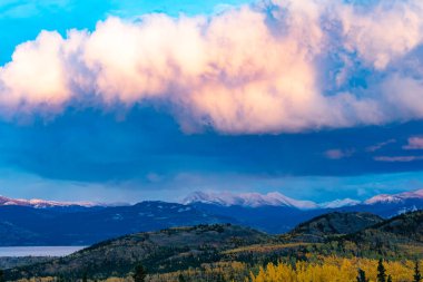Günbatımı güneşinde ağır bulutlar, Kanada Laberge Yukon Gölü 'nün sonbahar manzarası, Taiga Boreal Ormanı' nda.