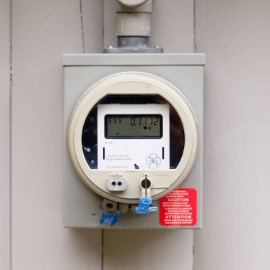 Modern smart grid residential digital power supply meter mounted outside on house wall clipart
