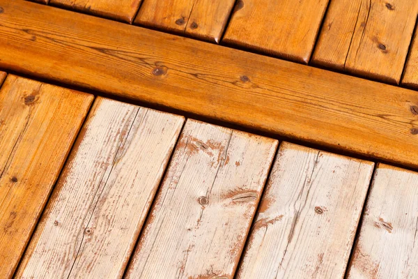 木製デッキボード部分的に透明保護屋外デッキ塗料汚れや部分的に未完成の風化生の木材表面で終了 — ストック写真