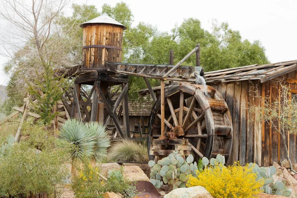 米国アリゾナ州ツーソンの近くの砂漠の庭の開花に西洋スタイルのパイオニアフロンティア水車の木造建築物 ロイヤリティフリーのストック画像