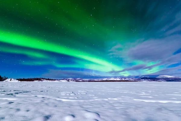 氷結したレイクラベルジュ ユーコン準州 カナダの冬の風景の上に緑の渦巻きを形成する強烈なオーロラやオーロラの壮大なディスプレイ — ストック写真