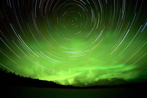 カナダ ユーコン準州のオーロラやオーロラの緑輝くディスプレイを持つ天体写真の星の道 — ストック写真