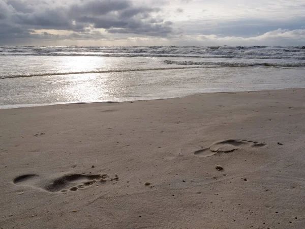 Ludzkie Odciski Gołych Stóp Mokrym Piasku Pięknej Plaży Burzliwym Oceanem — Zdjęcie stockowe