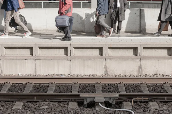 駅ホームに移動し ホーム下部の線路に到着する列車に乗る旅行者 — ストック写真