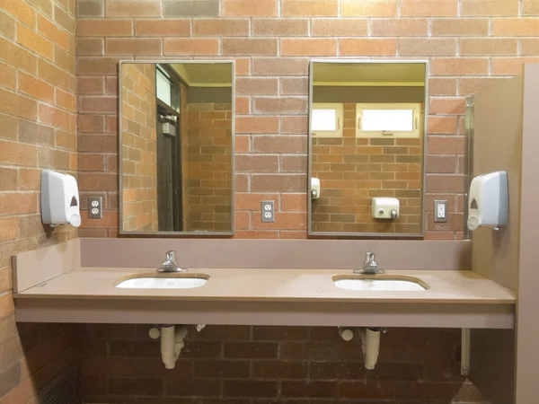 生レンガの壁にシンクとミラー付きのシンプルな公共の洗面所 — ストック写真
