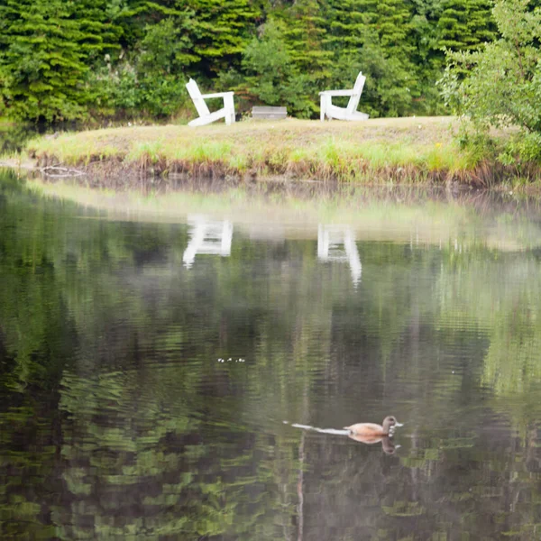 Two Wooden Adirondack Chairs Facing Each Other Lake Reflection Water — Stock Photo, Image