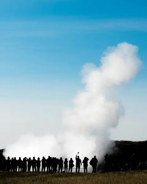 有名な観光名所の噴火を見て観光客のシルエットの群衆間欠泉ストロックルは ヨーロッパ アイスランド ハウカダラー州 ガイザーの背の高い列のお湯と蒸気によって矮星 — ストック写真