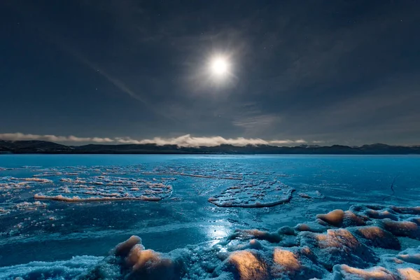 カナダ ユーコン準州の凍った湖ラベルジュの青い氷の表面に輝く満月 — ストック写真