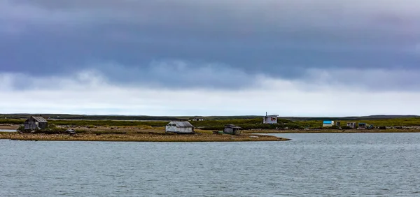 美しい海北極海沿岸には カナダのNwt ノースウエスト準州トゥクトゥクトゥクのInuvialuit町近くの海岸に小屋や小さなキャビンが点在しています — ストック写真
