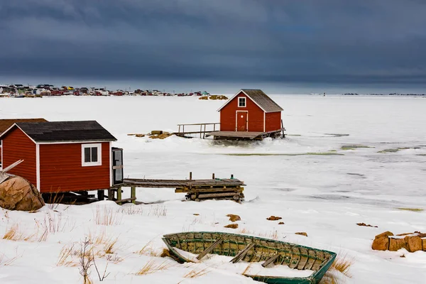 釣りステージの小屋や冷凍北大西洋の海岸で古い木製のスキフの行船は カナダのNl ニューファンドランド島のジョー バットの腕の出力町で ストック画像