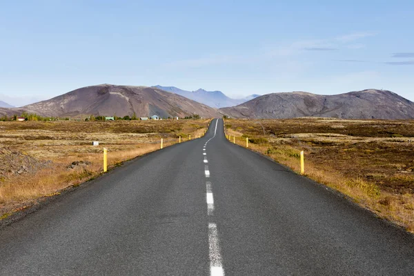 ゴールデンサークル地域 アイスランド ヨーロッパの遠くの山の範囲につながる不毛の火山の風景の舗装道路 — ストック写真