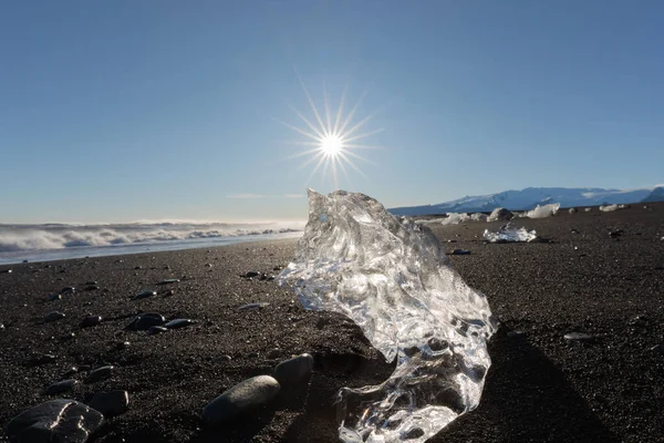 ジョクルサロン氷河ラグーンからの氷河氷は ダイヤモンドビーチ アイスランド ヨーロッパの太陽の下で黒い火山砂の輝きに洗われます — ストック写真