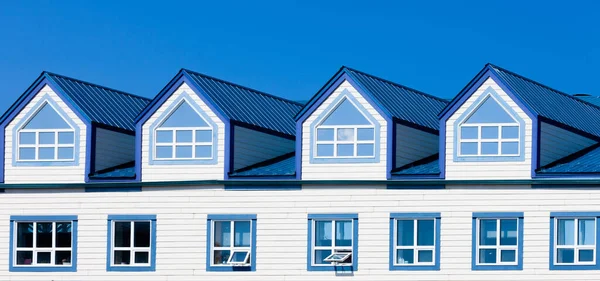 青い金属屋根の上階窓と4つのドーマーを構築するフレームの外観の詳細 — ストック写真