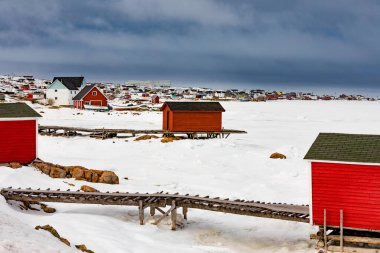 Fogo Adası, Newfoundland, NL, Kanada 'da donmuş Kuzey Atlantik Okyanusu kıyısındaki Joe Batt' s Arm balıkçı kasabasının balıkçı kulübeleri