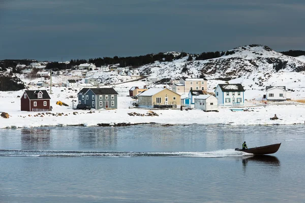 モーターボートは冬に伝統的な木製の塩箱住宅を渡すTwillingateの出力町のDurrell港に入ります ニューファンドランド島 カナダ — ストック写真