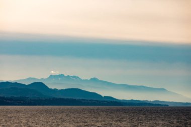 Vancouver Adası 'nın doğu kıyısı. Orman tepeleri ve dağların silueti. Britanya Kolumbiyası, BC, Kanada Pasifik Okyanusu kıyıları sisle kaplı.