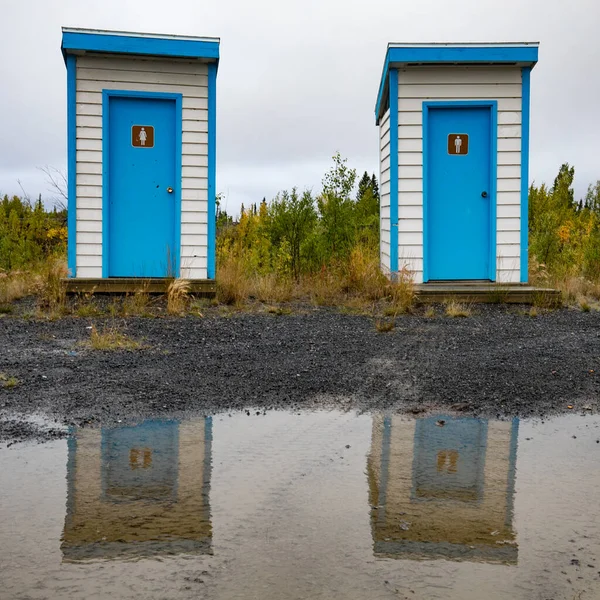 Colorful Simple Basic Outhouses Mirrored Big Water Puddle Left Heavy — Stock Photo, Image
