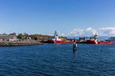 Kırmızı ve beyaz sahil güvenlik gemisi limanda.