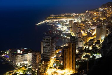 Monte Carlo panoraması gece aydınlandı. Lüks mimarisi olan şehir manzarası