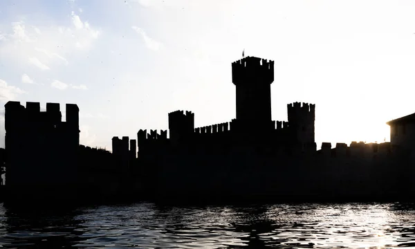Italy - Sirmone castle silhouette on the Garda lake at sunset. Medieval architecture with tower