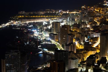 Monte Carlo panoraması gece aydınlandı. Lüks mimarisi olan şehir manzarası
