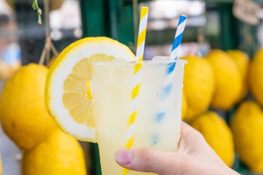 Yaz boyunca limon arkaplanlı sağlıklı taze limonata ile beyaz el.