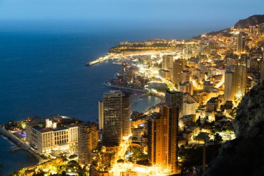 Monte Carlo panoraması gece aydınlandı. Lüks mimarisi olan şehir manzarası