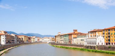 Pisa, İtalya - 29 Haziran 2023: Arno nehri üzerindeki renkli binalar. Kentsel ufuk çizgisi, seyahat noktası.