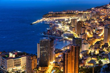 Monte Carlo panoraması gece aydınlandı. Lüks mimarisi olan şehir manzarası