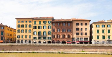 Pisa, İtalya - 29 Haziran 2023: Arno nehri üzerindeki renkli binalar. Kentsel ufuk çizgisi, seyahat noktası.