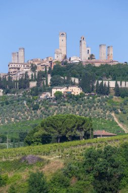 San Gimignano köyü, İtalya - yeşil kırsal bölge, mavi gökyüzü, şehir ve kuleleri olan tepe manzarası