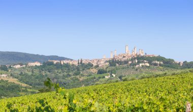 San Gimignano köyü, İtalya - yeşil kırsal bölge, mavi gökyüzü, şehir ve kuleleri olan tepe manzarası